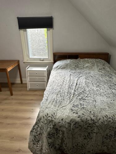 a bedroom with a bed and a desk and a window at Tom home in Toronto