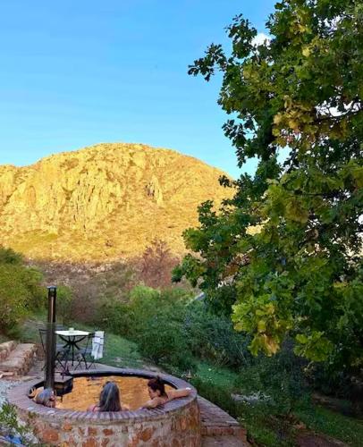 two women in a bath tub with a mountain in the background at Porcupine Hills Olive and Guest Farm in Botrivier