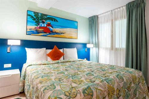 a bedroom with a large bed with a colorful bedspread at Royal Islander Club Resort La Terrasse in Lowlands