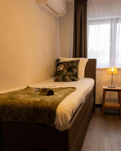 a bedroom with a bed with a cat laying on it at Bed and Breakfast De Heren van Valkenburg in Valkenburg