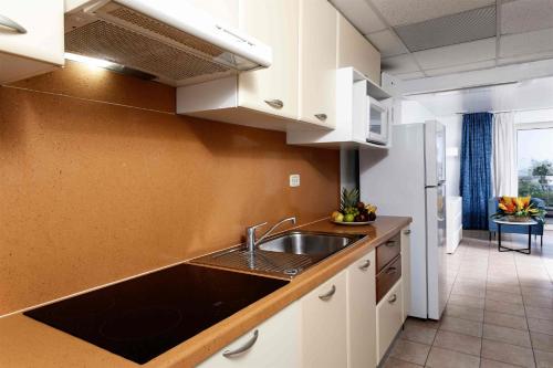 a kitchen with a sink and a counter top at Royal Islander Club Resort La Terrasse in Lowlands