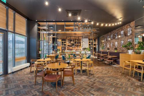 a restaurant with tables and chairs in a room at Park Inn by Radisson Riga Valdemara in Rīga