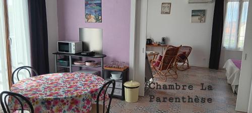 a dining room with a table and a microwave at Chambre d'hôtes du Mas Julianas in Saint-Laurent-de-la-Salanque