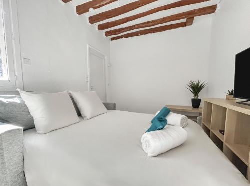 a bedroom with a white bed and a tv at Studio fonctionnel, cosy & calme en centre-ville in Melun