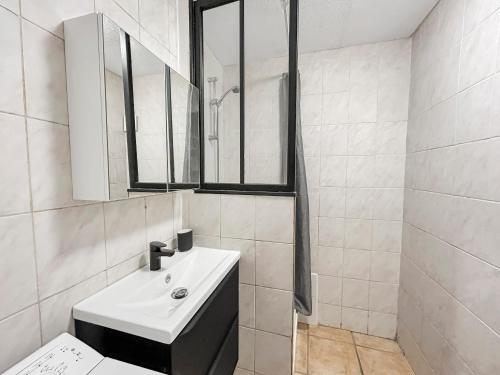 a white bathroom with a sink and a mirror at Studio fonctionnel, cosy & calme en centre-ville in Melun