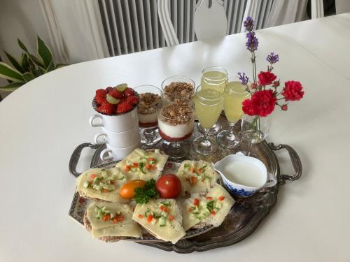 a tray of food and drinks on a table at B&B Österlens RosenTrädgård in Glemmingebro