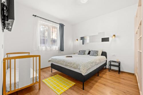 a bedroom with a bed and a yellow rug at DV Apartment in Pješčana Uvala 