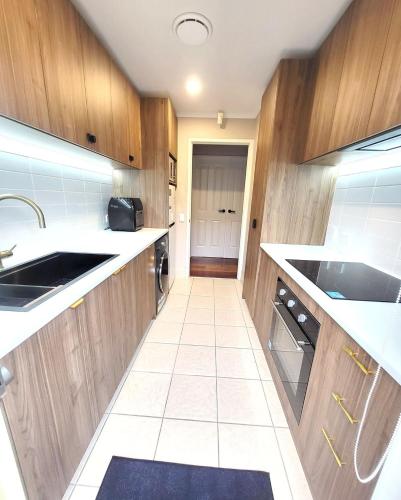a kitchen with wooden cabinets and a sink at A slice of Melbourne! Room 1 in Craigieburn