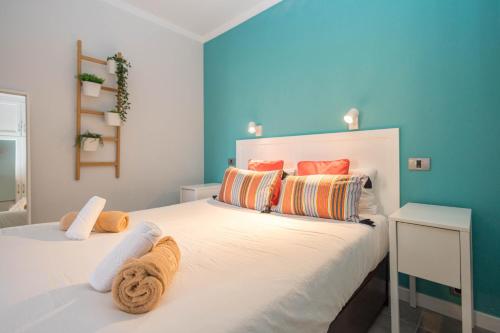 1 dormitorio con cama blanca y almohadas coloridas en Canteras Seaviews - Balcony & Beach, en Guanarteme