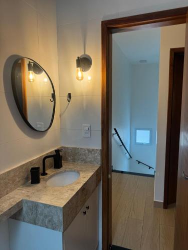 un bagno con lavandino, specchio e doccia di Casa completa em Caraguatatuba - Rio do Ouro a Caraguatatuba