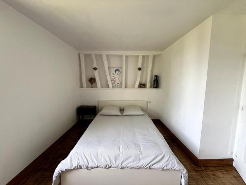 a small bedroom with a white bed in it at Maison familiale à la campagne in Villers-sur-Auchy