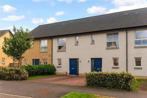 an apartment building with blue doors on a street at Oatlands Oasis-FREE PARKING-2 Minutes from M74 in Glasgow