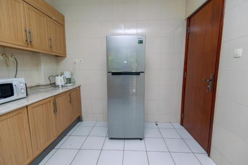 a stainless steel refrigerator in a kitchen with a microwave at Downtown Nyumbani cottages and Apartments in Kigali