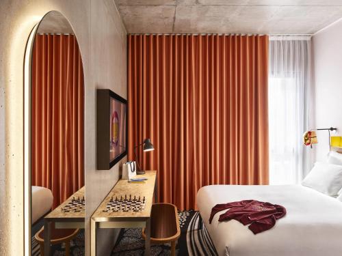 a hotel room with a bed and a desk and a window at Mama Shelter Lille in Lille