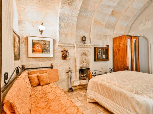 a bedroom with a bed and a fireplace at Castle Inn Cave Cappadocia in Ortahisar