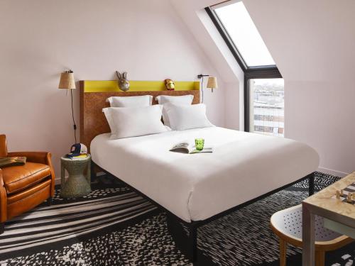 a bedroom with a large white bed and a window at Mama Shelter Lille in Lille