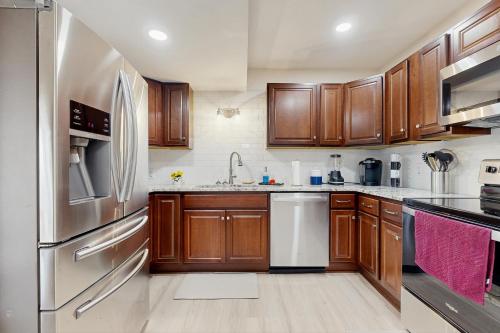 Una cocina con gabinetes de madera y electrodomésticos de acero inoxidable. en Gibbs Getaway, en Leicester