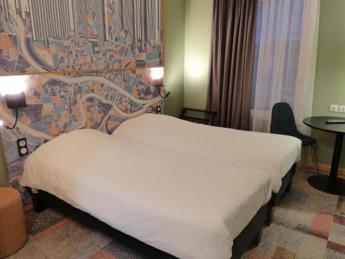 a hotel room with a bed and a wall at Ibis Styles Lyon Croix Rousse in Lyon