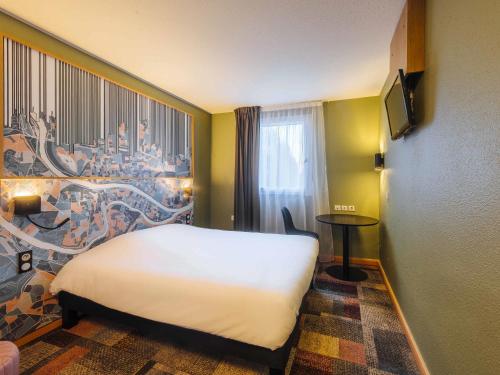 a hotel room with a white bed and a window at Ibis Styles Lyon Croix Rousse in Lyon
