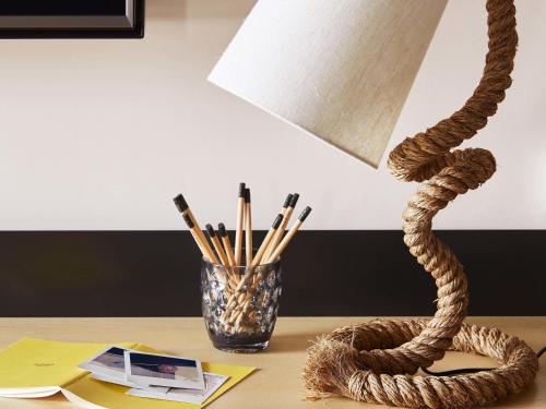 a table with a lamp and a vase with pencils at Mama Shelter London - Shoreditch in London