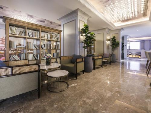 a lobby with couches and tables and shelves of books at Mercure Xi'an Downtown in Xi'an