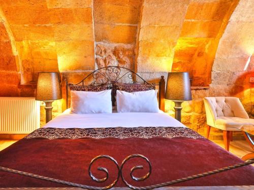 a bedroom with a large bed with two lamps at Castle Inn Cave Cappadocia in Ortahisar