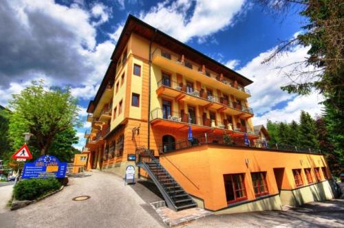 a yellow building with a staircase in front of it at Thermenhotel Krone - next to skilift in Bad Gastein