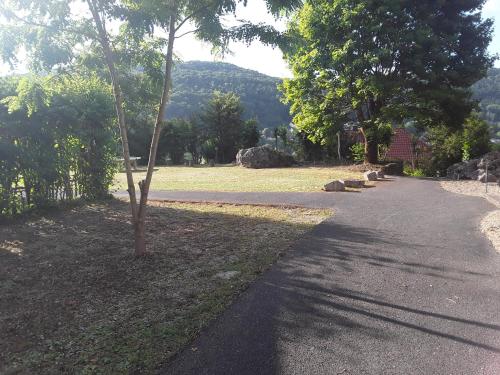 a walkway leading to a park with trees and rocks at Sporthotel Streitberg in Streitberg
