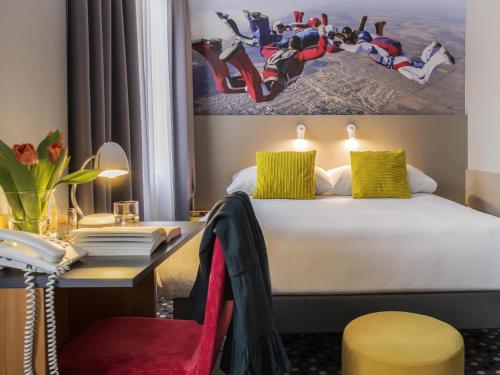a hotel room with a bed and a desk at ibis Styles Warszawa West in Mory