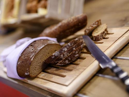 a loaf of bread on a cutting board with a knife at ibis Regensburg Zentrum in Regensburg