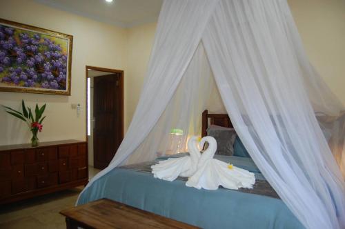 two swans are sitting on top of a bed at Beachfront Villa Jepun Segara in Banjar