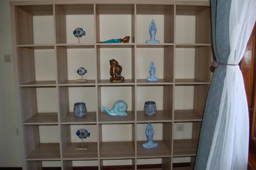 a book shelf filled with blue and white vases at Beachfront Villa Jepun Segara in Banjar