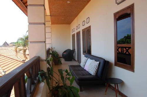 a balcony of a house with a chair and a window at Beachfront Villa Jepun Segara in Banjar