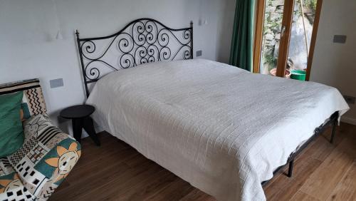 a bedroom with a white bed and a chair at Casa Lago Azzurro Atelier in Cannobio