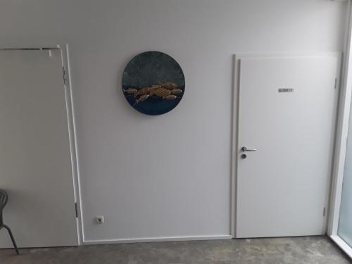 a room with two refrigerators and a clock on the wall at Sporthotel Streitberg in Streitberg