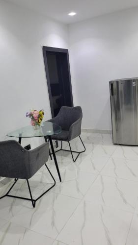 a living room with a glass table and two chairs at Seven kings apartment Lekki in Araromi