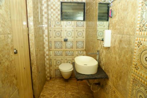 a small bathroom with a toilet and a window at Hotel Shirdi Park Inn 80 Meters From Sai Samadhi Temple in Shirdi