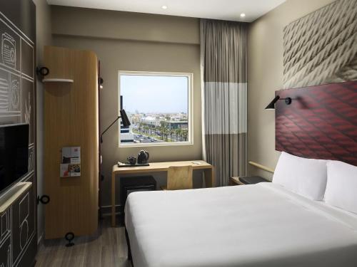 a hotel room with a bed and a window at Ibis Jeddah Malik Road in Jeddah