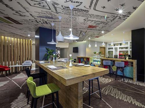 a room with a bar with a table and chairs at Ibis Jeddah Malik Road in Jeddah