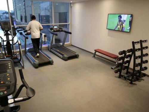 a man walking on a treadmill in a gym at Ibis Jeddah Malik Road in Jeddah