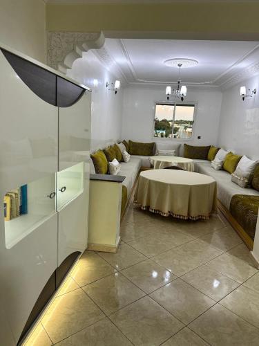 una sala de estar con un sofá y una mesa en Réservez dès maintenant Calme confort et proximité, en Oulad Mbark
