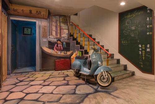 a vespa parked in a room with a chalkboard at Beimen WOW Poshtel in Taipei
