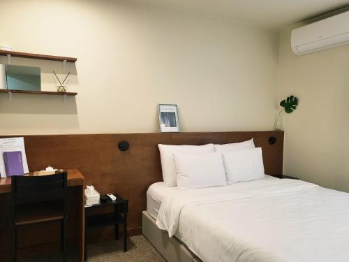 a hotel room with a bed and a nightstand with a bed sidx sidx sidx at jeonju hotel book and type in Jeonju