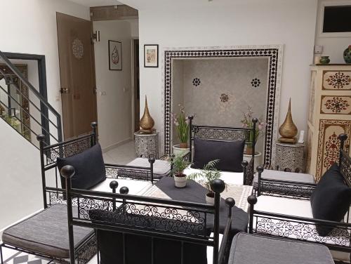 a living room with chairs and a table and a mirror at Ryad Ayad in Marrakech