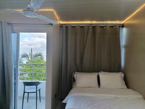 a bedroom with a bed and a balcony with a chair at Portia beach grand 2 in Male City