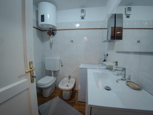 Un baño blanco con inodoro y lavabo. en Pila- ski in ski out- appartamento YUMI, en Pila