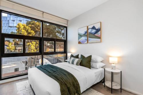 a bedroom with a white bed and a large window at Luxe 3BR CBD Apartment with River Views and Resort Style Amenities in Melbourne