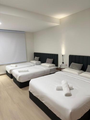 a hotel room with three beds in a room at LM Homestay in Kulim