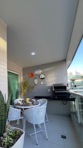 a kitchen with a table and chairs on a balcony at Praia Grande Arraial do Cabo in Arraial do Cabo