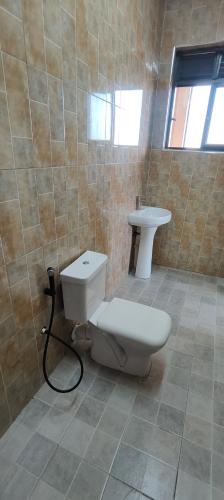 a bathroom with a toilet and a sink at 1 minute walk to Victoria Mall in Entebbe